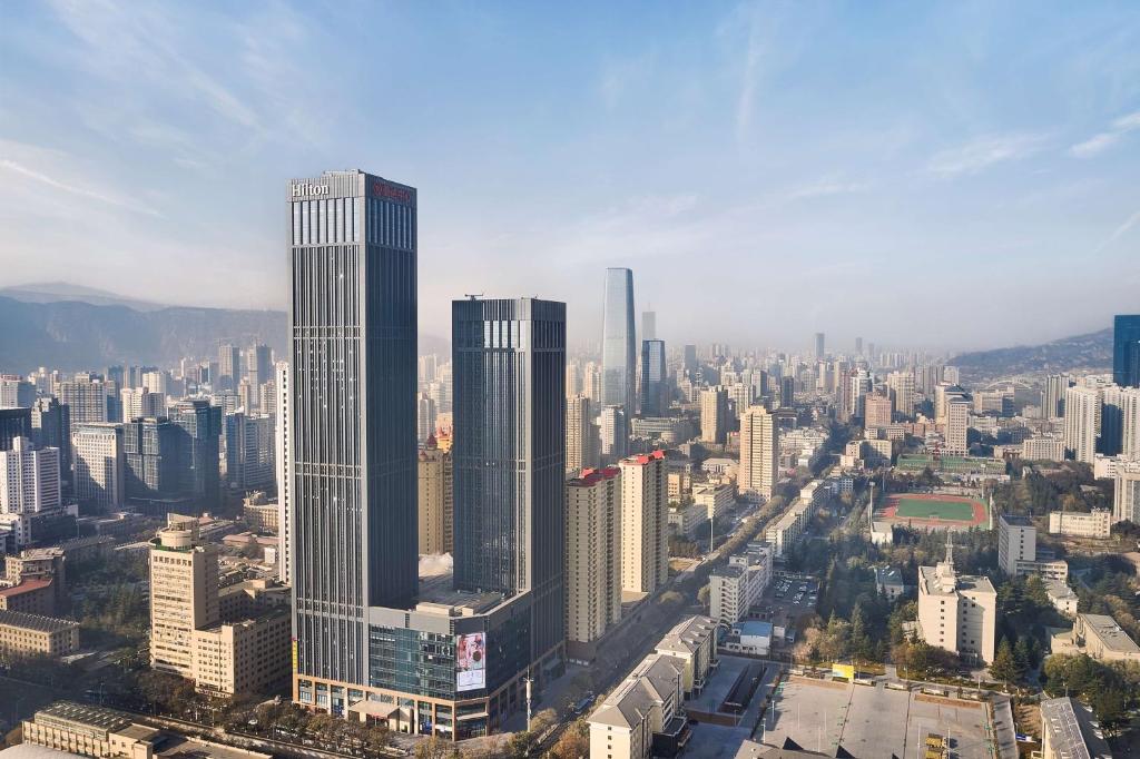 une vue aérienne sur une ville avec de grands bâtiments dans l'établissement Hilton Lanzhou City Center, à Lanzhou