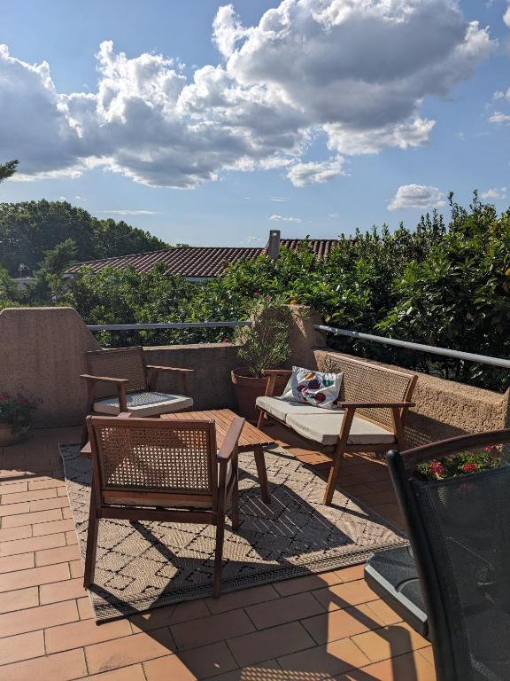 un patio avec deux chaises et une table sur le toit dans l'établissement Gîte Botanica, à Gignac