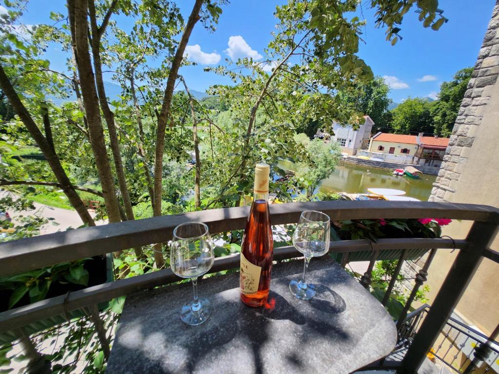 - une bouteille de vin assise sur une table avec deux verres dans l'établissement Lake Pearls, à Virpazar