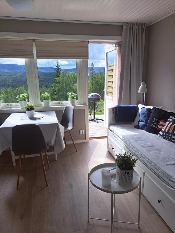 a living room with a bed and a table and a window at Mysig lägenhet med fjällutsikt i Sälen in Sälen