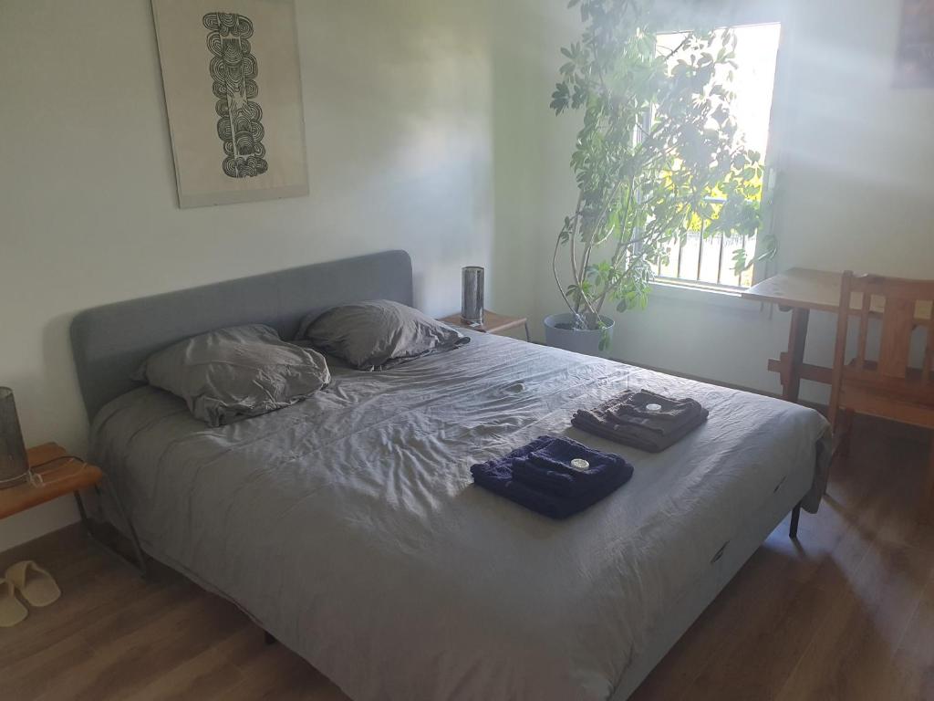 Una cama en un dormitorio con dos bolsas. en Chez Frédéric, en Saint-Malo