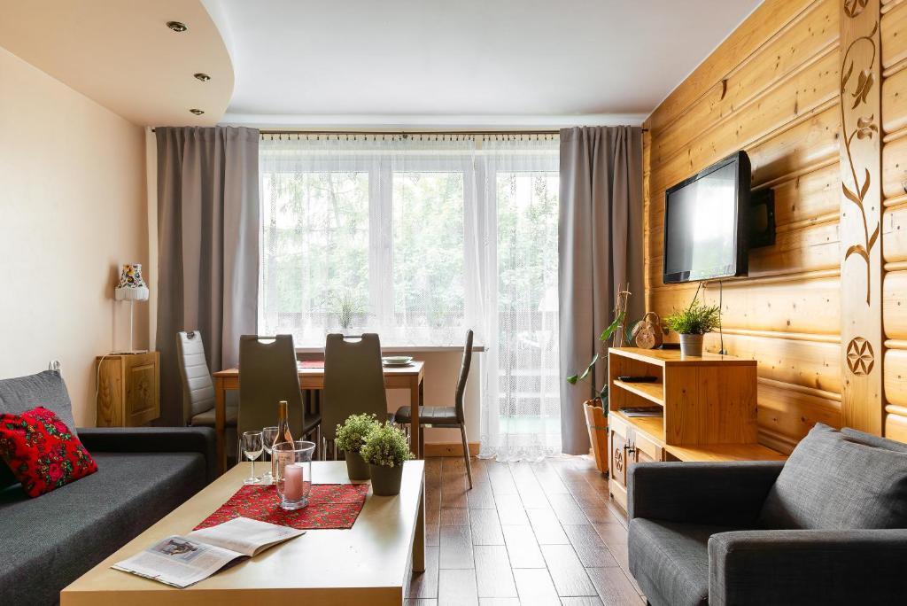 扎科帕內的住宿－Apartament Widok Zakopane，一间带桌子的客厅和一间餐厅