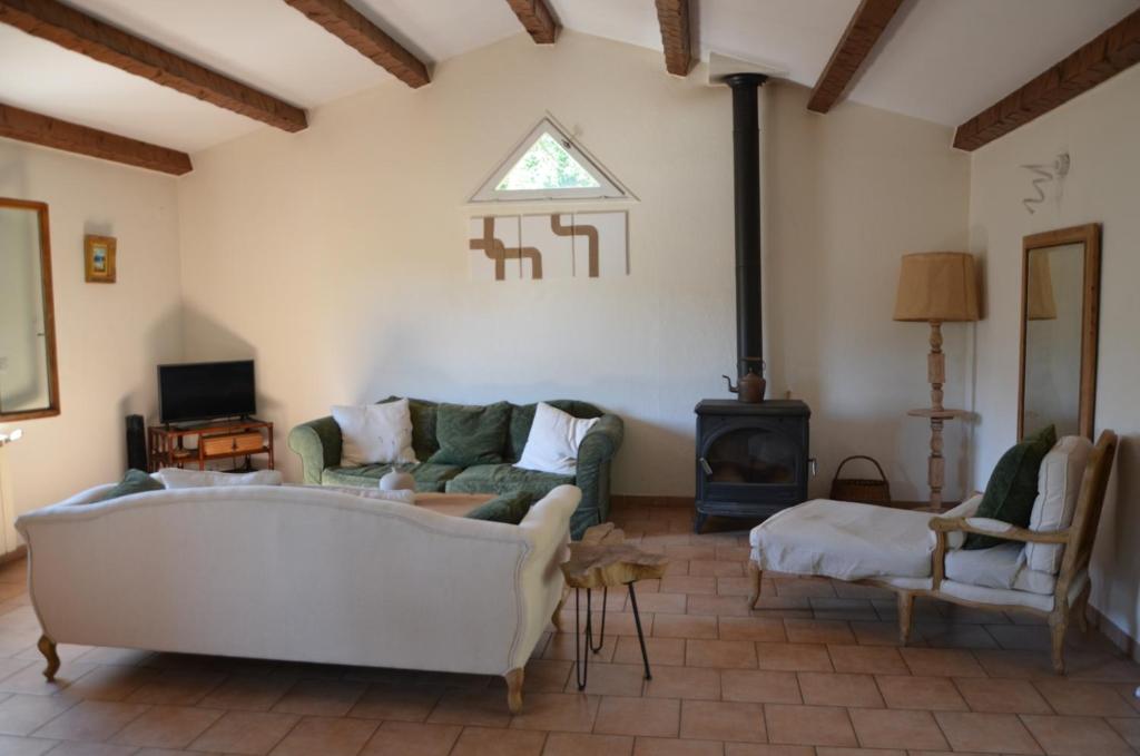 a living room with a couch and a stove at Maison Amandre en Pleine Nature - Mas Lou Castanea in Collobrières