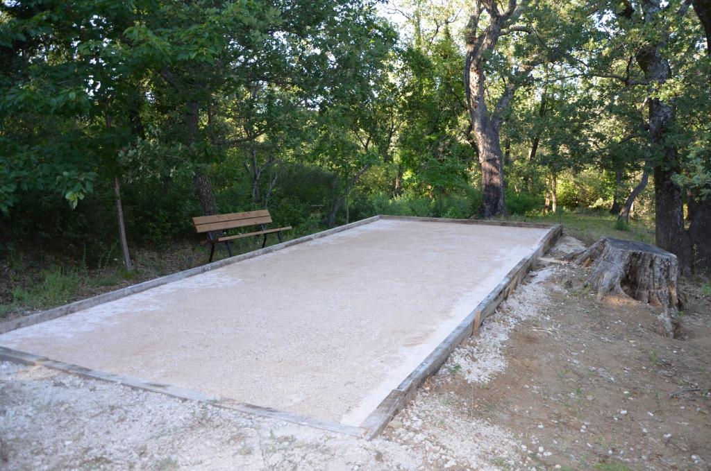 a large concrete pad with a bench in a park at Maison Amandre en Pleine Nature - Mas Lou Castanea in Collobrières