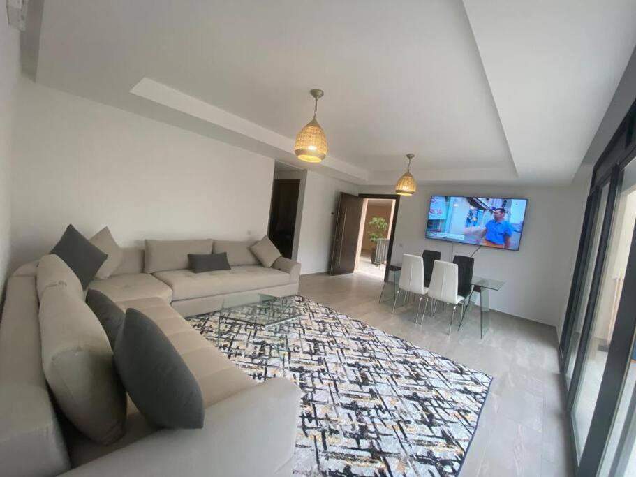 un soggiorno con divano e TV a schermo piatto di New Luxury Duplex Apt Taghazout a Taghazout