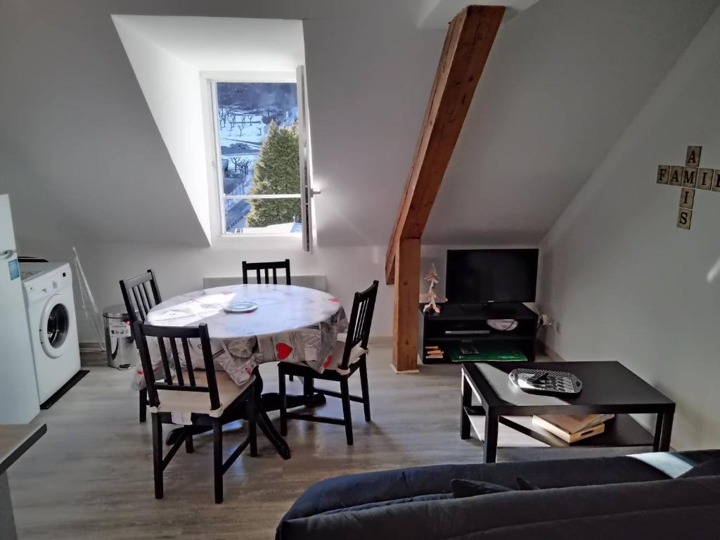 un salon avec une table et des chaises dans l'établissement T3 HYPER CENTRE MONT-DORE, à Le Mont-Dore