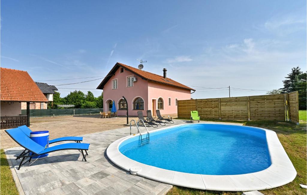 einen Pool in einem Garten mit Stühlen und einem Haus in der Unterkunft Stunning Home In Turnisce With Outdoor Swimming Pool, Jacuzzi And Wifi 