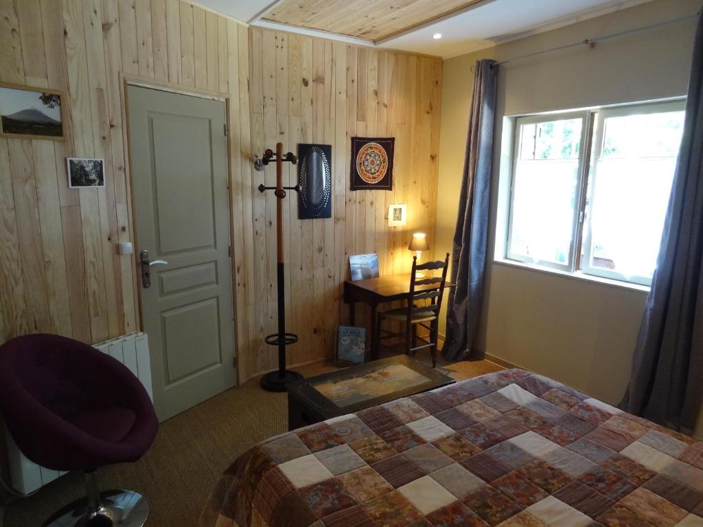 a bedroom with a bed and a window at Les Chambres de la Forêt in Juvigny-sous-Andaine