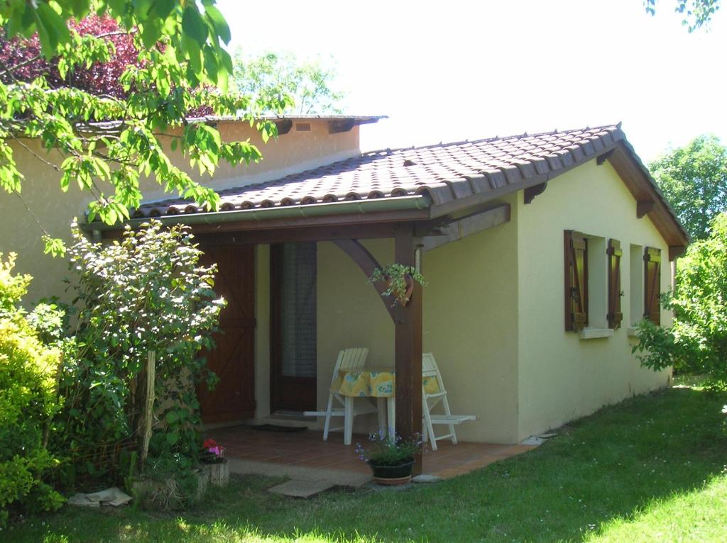 a small white house with a table and chairs at Gite Max in Payrac