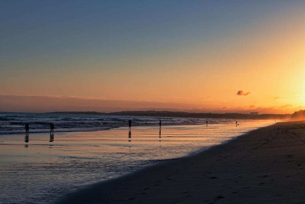 een zonsondergang op een strand met de oceaan bij Domes Lake Algarve, Autograph Collection in Vilamoura