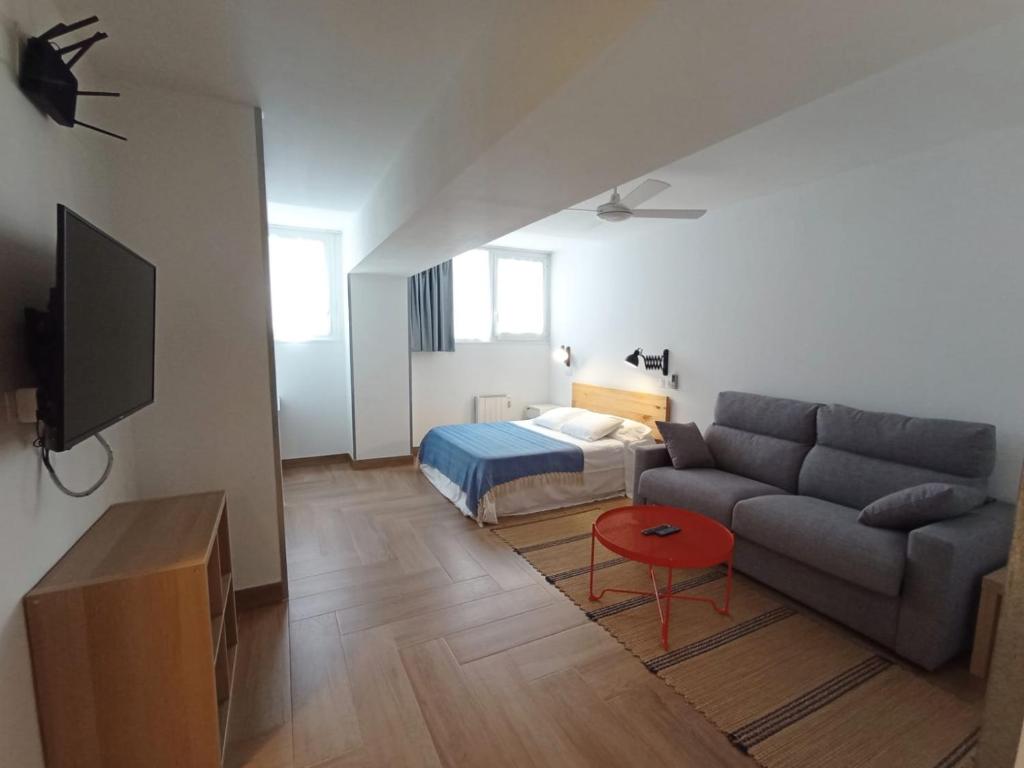 a living room with a couch and a bed at Apartamento full equip. in Bilbao