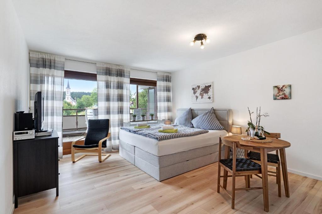 uma sala de estar com uma cama e uma mesa em Apartment Schwarzwald em Schönwald
