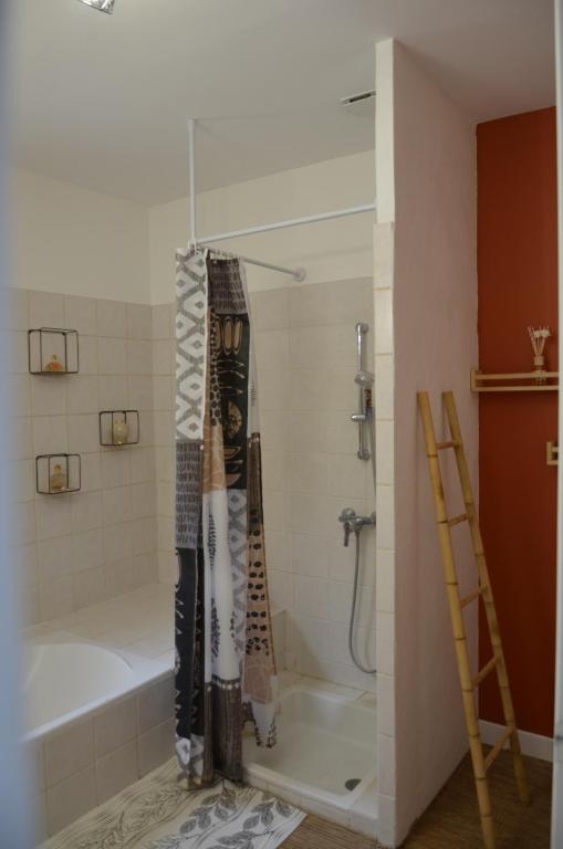 a bathroom with a tub and a shower with a shower curtain at Maison Amandre en Pleine Nature - Mas Lou Castanea in Collobrières