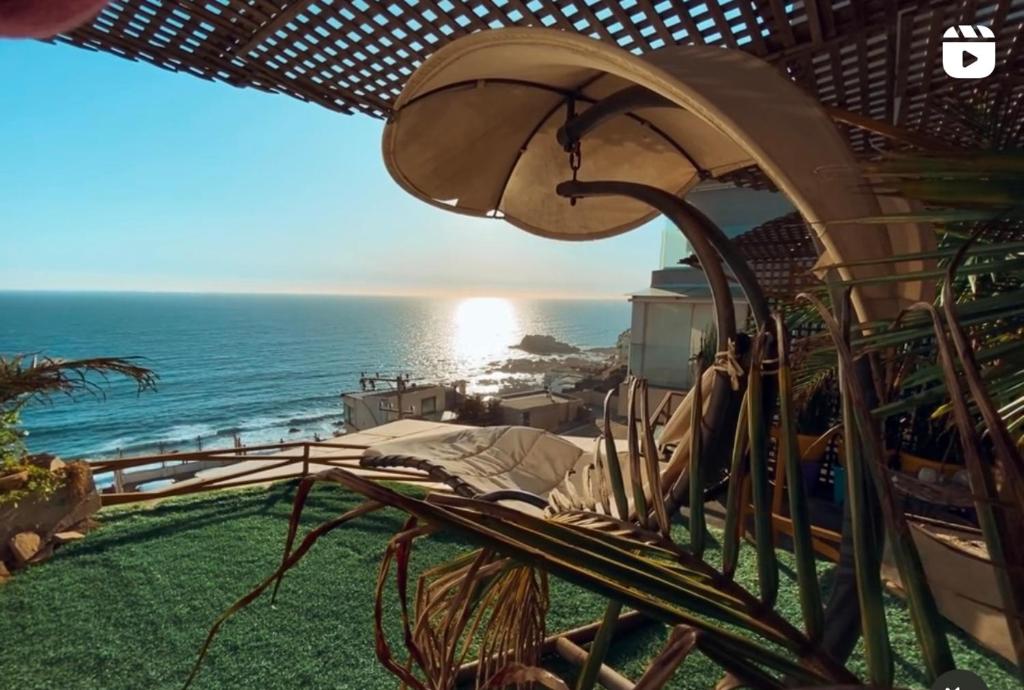 a view of the ocean from a resort with an umbrella at Pacificsunset Reñaca in Viña del Mar