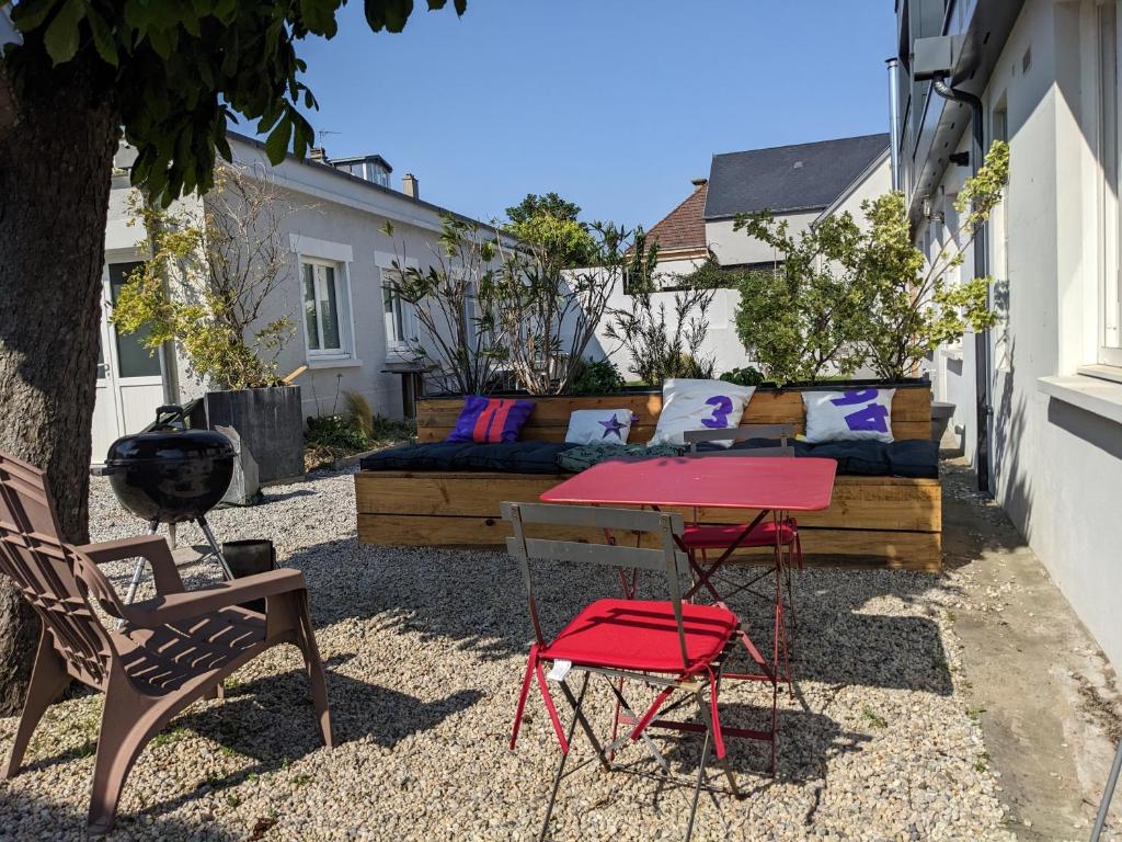 un patio con mesa, sillas y sofá en La corderie du Lude, en Granville