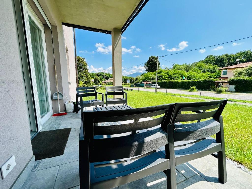 a porch with two benches on the side of a house at Kibilù - Via Galvani con parcheggio e giardino privato in Ispra