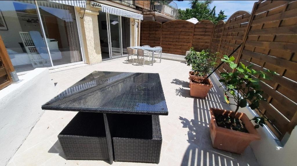 eine Terrasse mit einem Tisch und einigen Topfpflanzen in der Unterkunft Sunny Gassin in Gassin