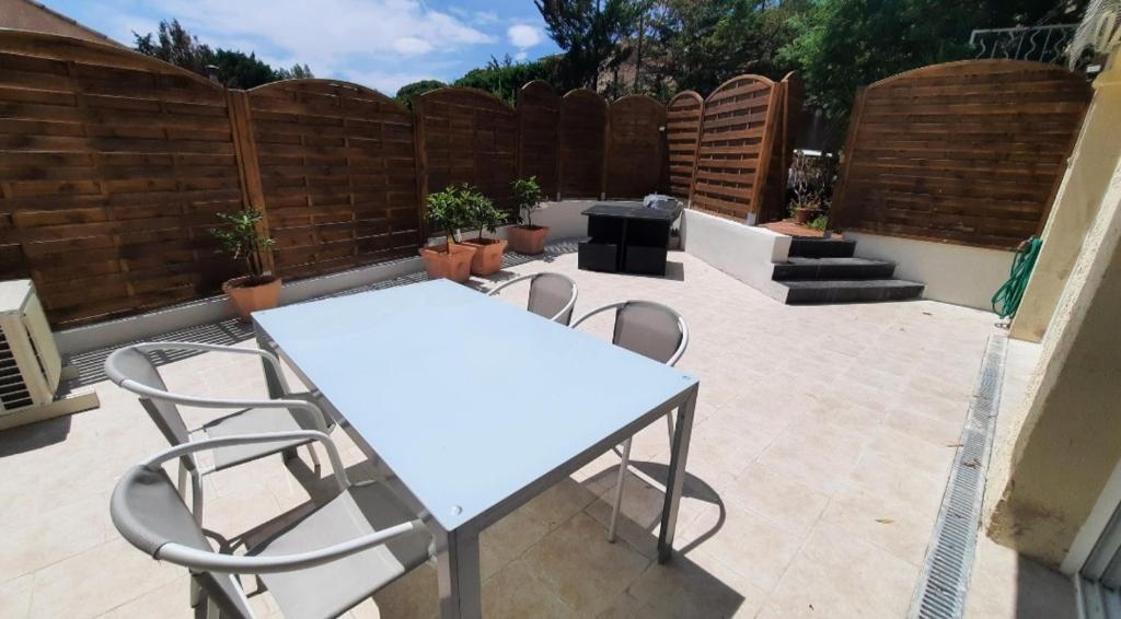 - une table et des chaises blanches sur la terrasse dans l'établissement Sunny Gassin, à Gassin