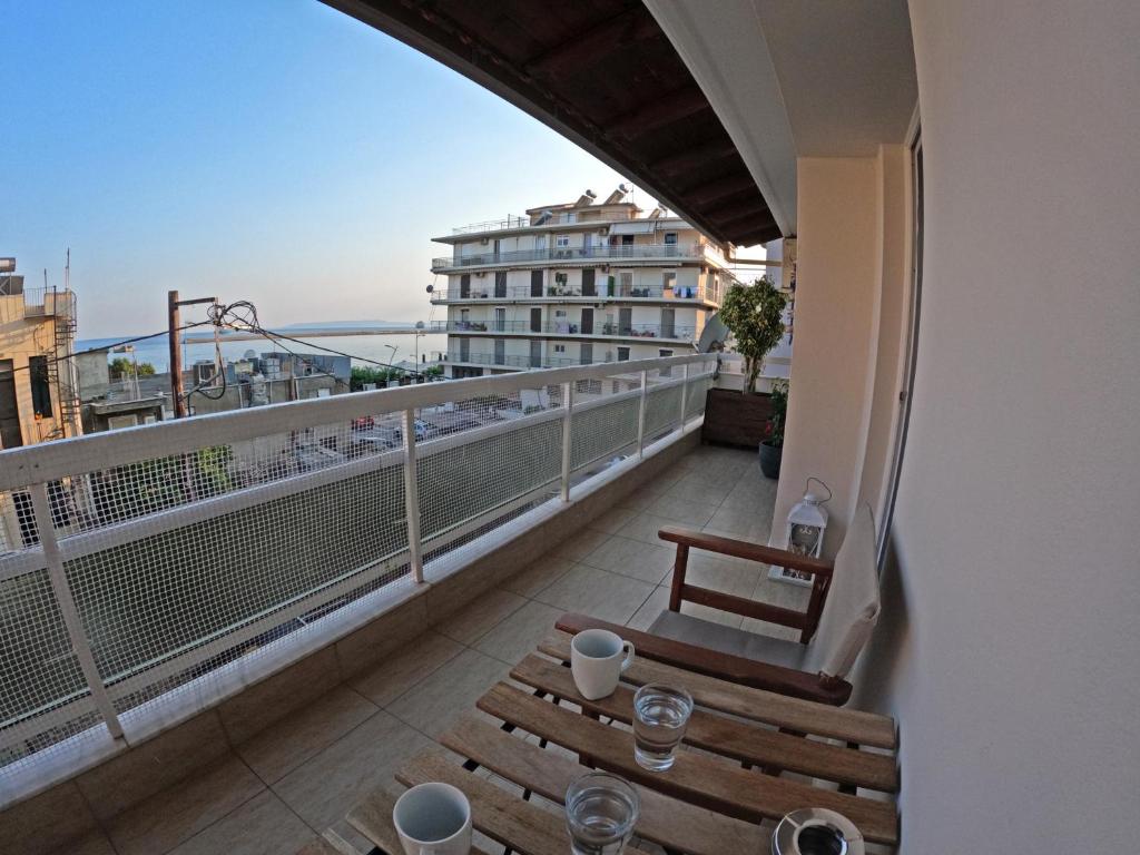 uma varanda com uma mesa e cadeiras e um edifício em Kalamata Beachside Bliss em Kalamata