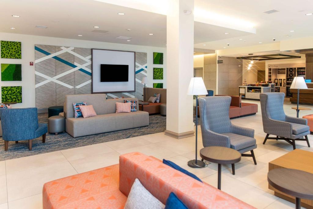 a lobby with couches and chairs and a tv at Hilton Garden Inn Mattoon, IL in Mattoon