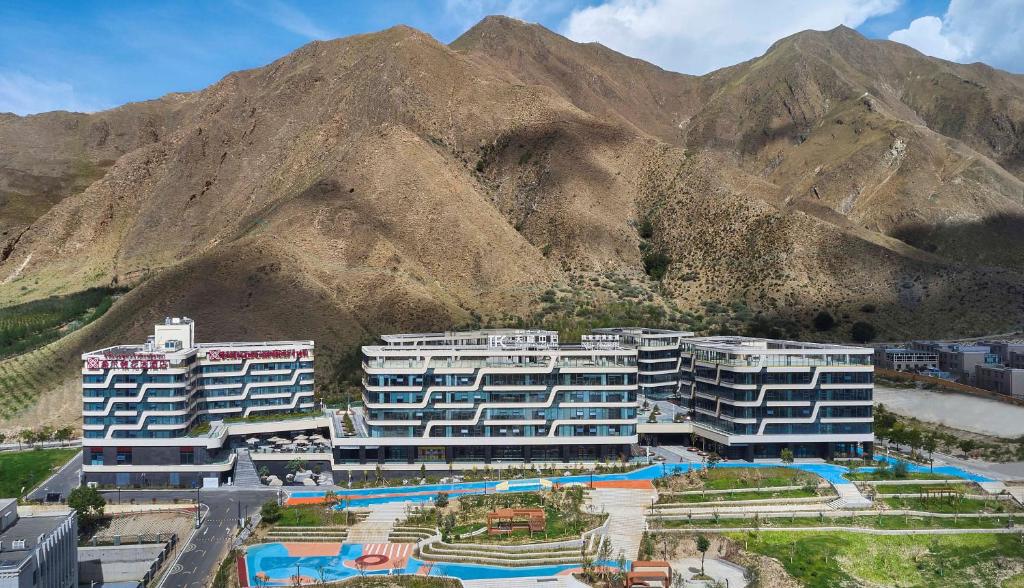 eine Luftansicht eines Resorts mit Bergen im Hintergrund in der Unterkunft Hilton Garden Inn Lhasa in Lhasa