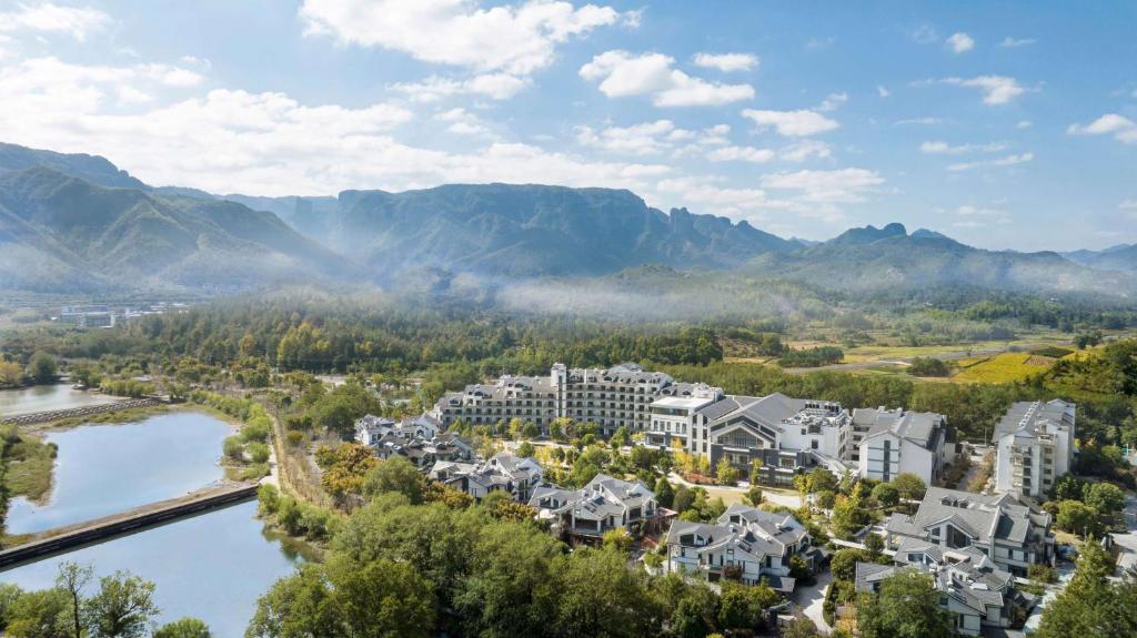 an aerial view of a resort with a river and mountains at Doubletree By Hilton Taizhou Shenxianju in Taizhou