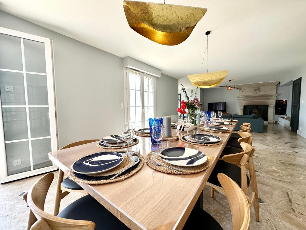 a dining room with a long wooden table and chairs at LUXURY ! Maison spacieuse de standing – Proche des plages in Ploemeur