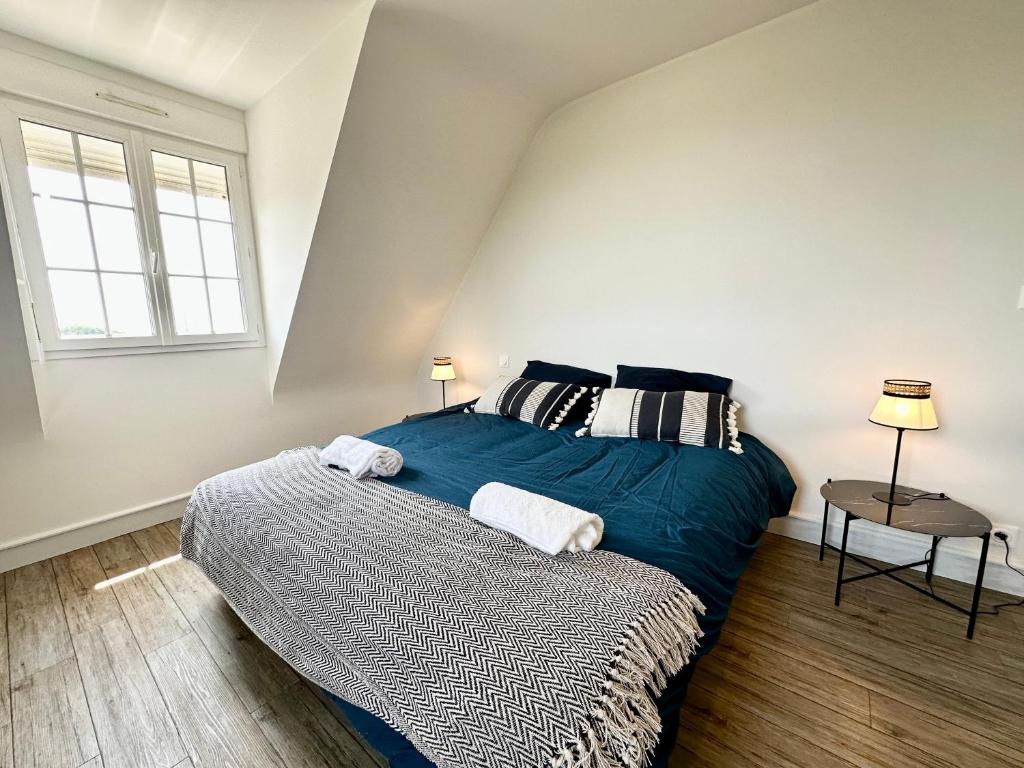 a bedroom with a bed with blue sheets and a window at LUXURY ! Maison spacieuse de standing – Proche des plages in Ploemeur