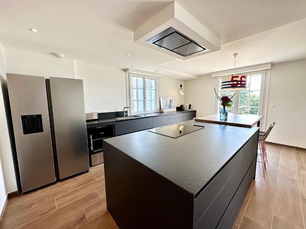 a large kitchen with a large black counter top at LUXURY ! Maison spacieuse de standing – Proche des plages in Ploemeur