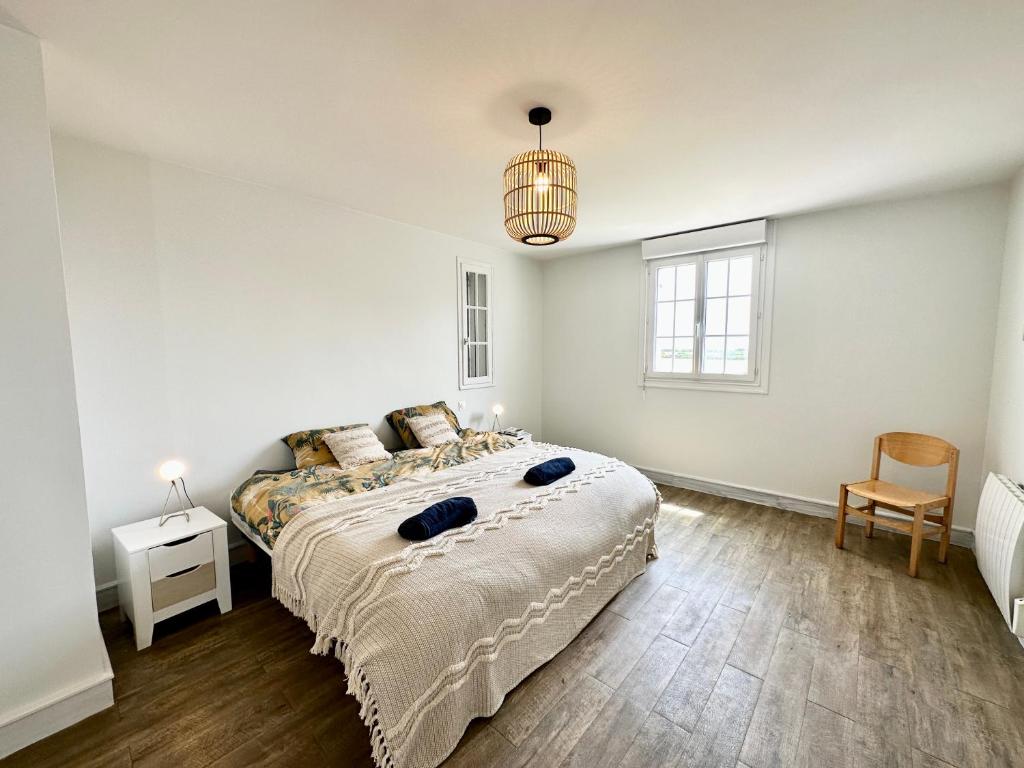 a white bedroom with a bed and a chair at LUXURY ! Maison spacieuse de standing – Proche des plages in Ploemeur