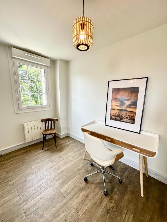 a room with a desk and a chair and a chandelier at LUXURY ! Maison spacieuse de standing – Proche des plages in Ploemeur