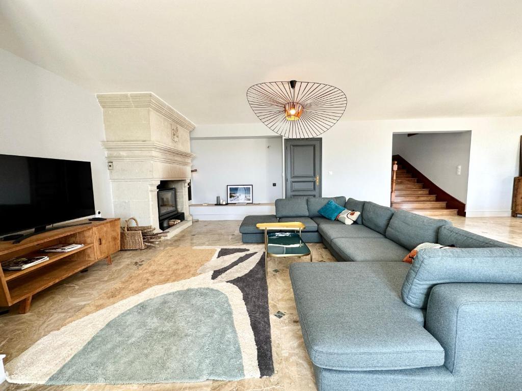 a living room with a blue couch and a tv at LUXURY ! Maison spacieuse de standing – Proche des plages in Ploemeur