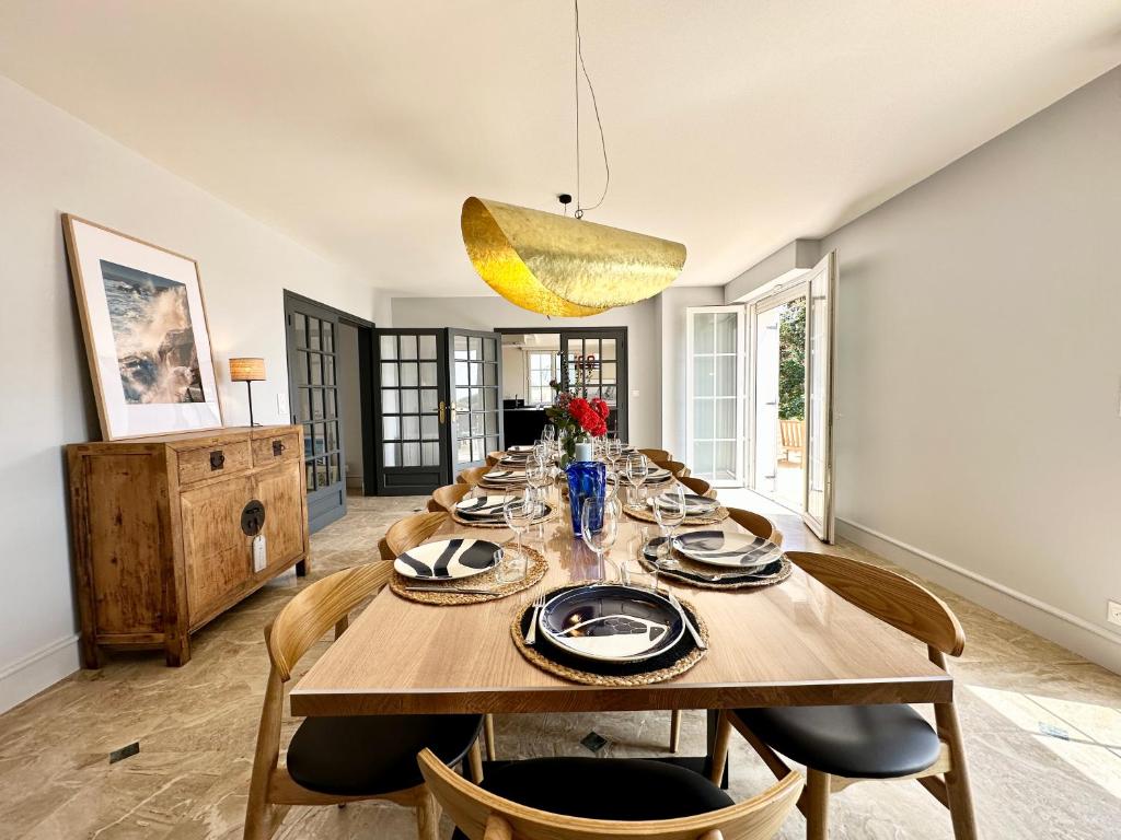 a dining room with a wooden table and chairs at LUXURY ! Maison spacieuse de standing – Proche des plages in Ploemeur