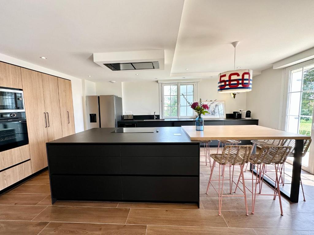 a kitchen with a black island and a counter top at LUXURY ! Maison spacieuse de standing – Proche des plages in Ploemeur
