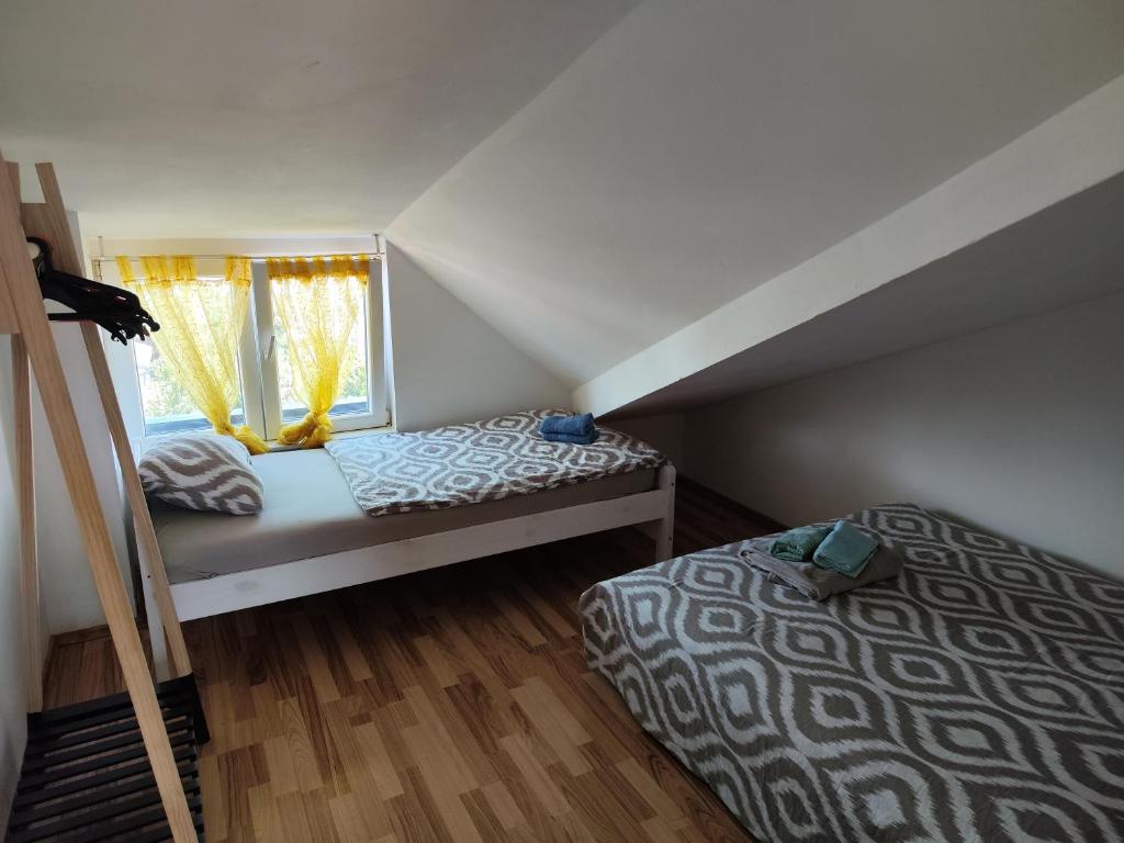 a attic bedroom with two beds and a window at Apartments Ivo in Njivice