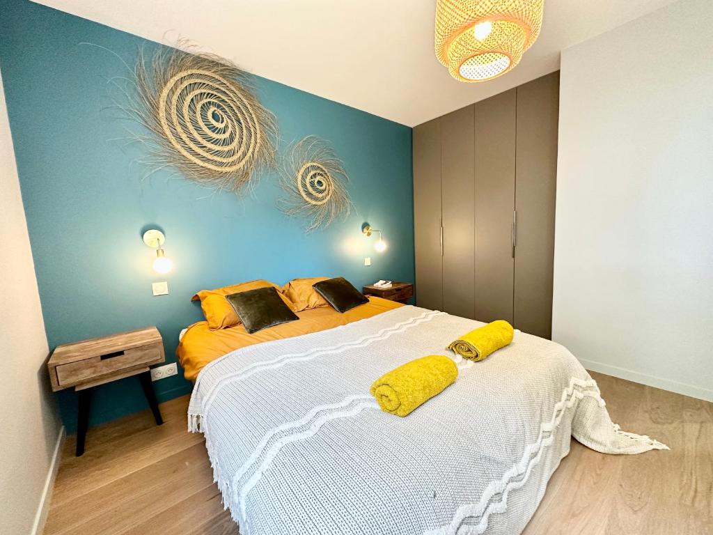 a bedroom with a large bed with yellow pillows on it at LUXURY ! Maison spacieuse de standing – Proche des plages in Ploemeur