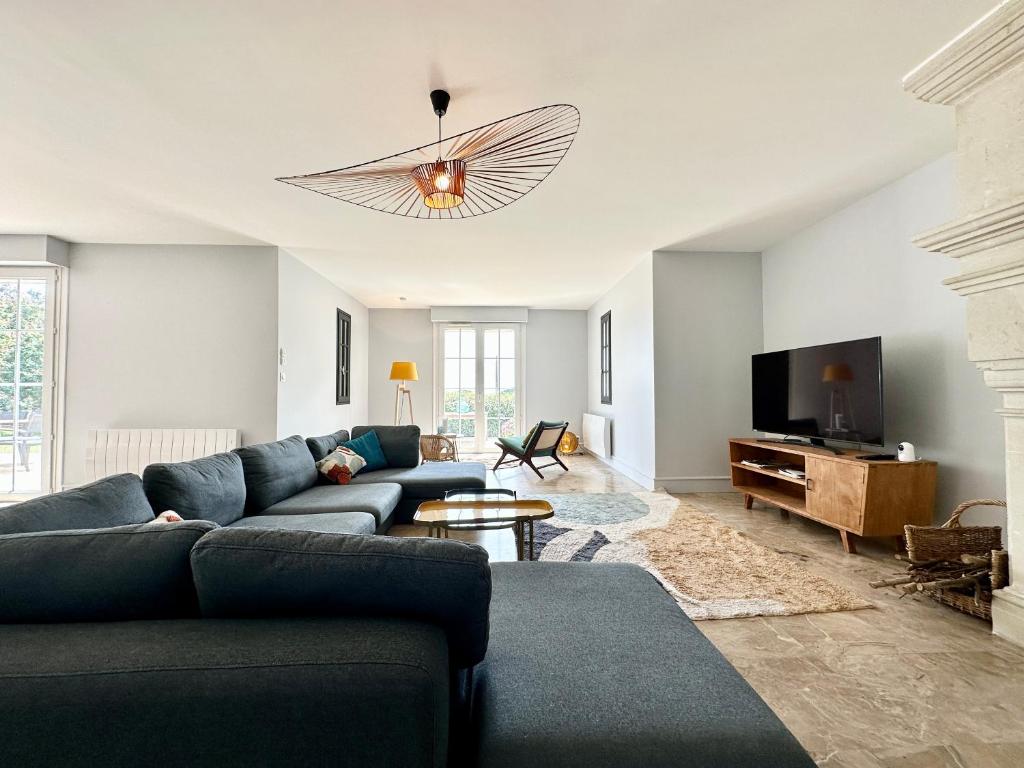 a living room with a blue couch and a tv at LUXURY ! Maison spacieuse de standing – Proche des plages in Ploemeur