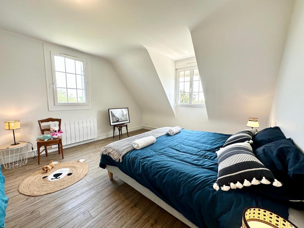 a bedroom with a large blue bed in a attic at LUXURY ! Maison spacieuse de standing – Proche des plages in Ploemeur