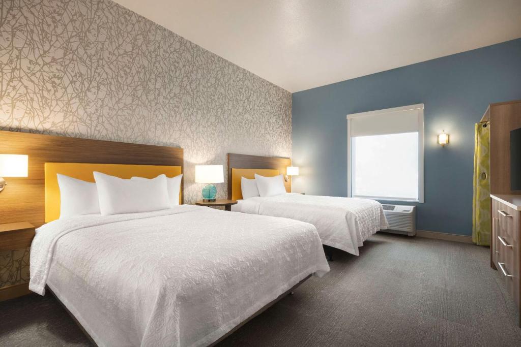 a hotel room with two beds and a window at Home2 Suites By Hilton Colorado Springs I-25 Central in Colorado Springs