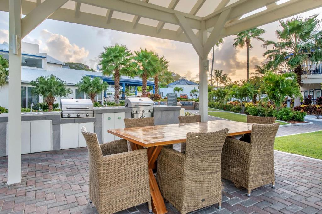 an outdoor patio with a wooden table and chairs at Hilton Vacation Club Flamingo Beach Sint Maarten in Simpson Bay