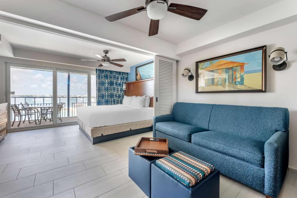 a living room with a blue couch and a bed at Hilton Vacation Club Flamingo Beach Sint Maarten in Simpson Bay