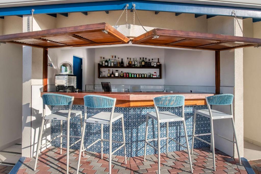 a kitchen with a bar with blue chairs at Hilton Vacation Club Flamingo Beach Sint Maarten in Simpson Bay