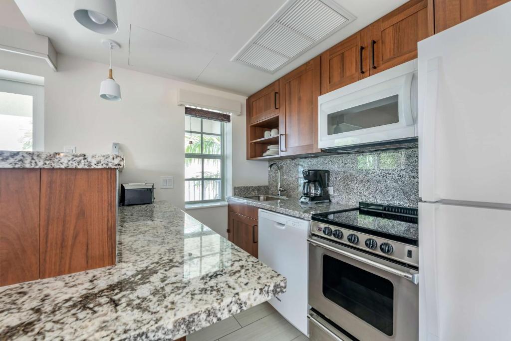 a kitchen with white appliances and wooden cabinets at Hilton Vacation Club Flamingo Beach Sint Maarten in Simpson Bay