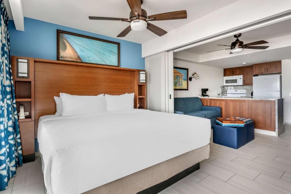 a bedroom with a large bed and a kitchen at Hilton Vacation Club Flamingo Beach Sint Maarten in Simpson Bay
