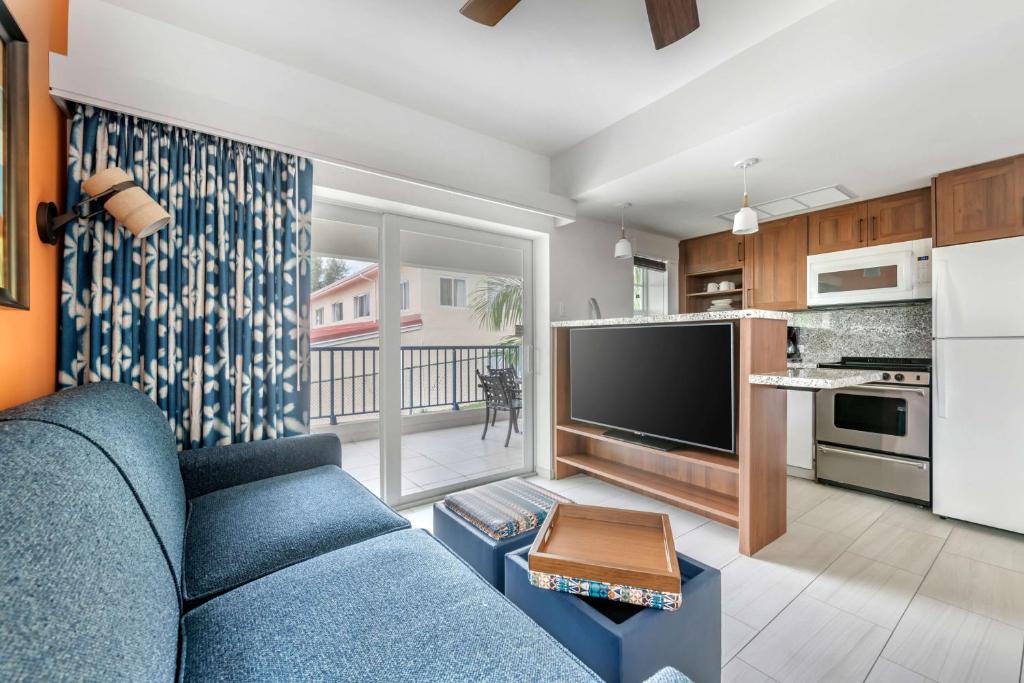 a living room with a blue couch and a kitchen at Hilton Vacation Club Flamingo Beach Sint Maarten in Simpson Bay