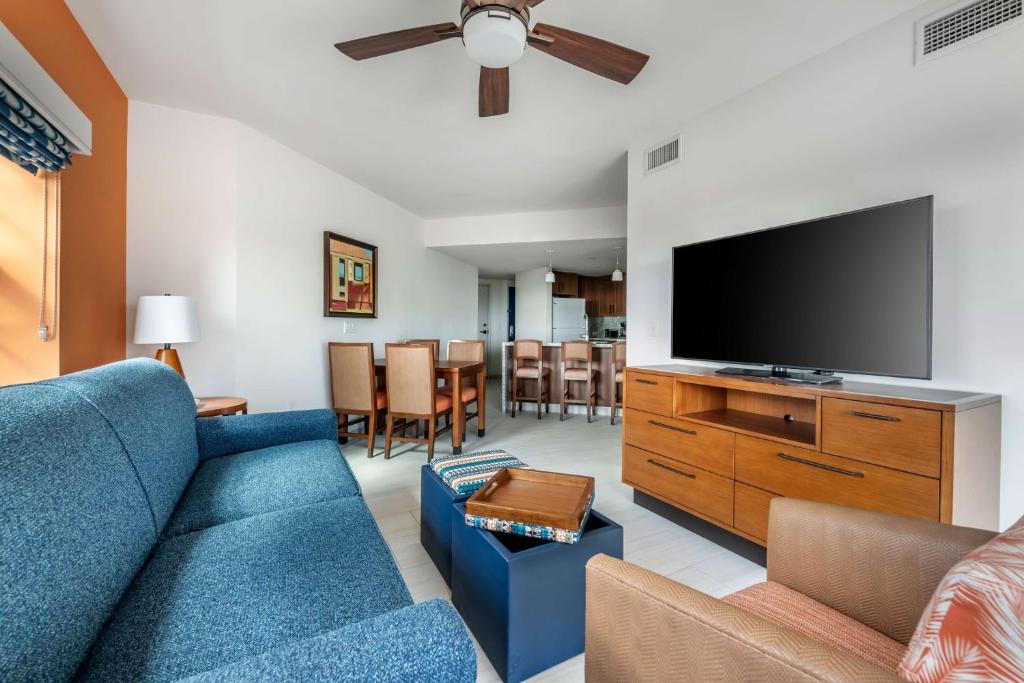 a living room with a blue couch and a flat screen tv at Hilton Vacation Club Flamingo Beach Sint Maarten in Simpson Bay