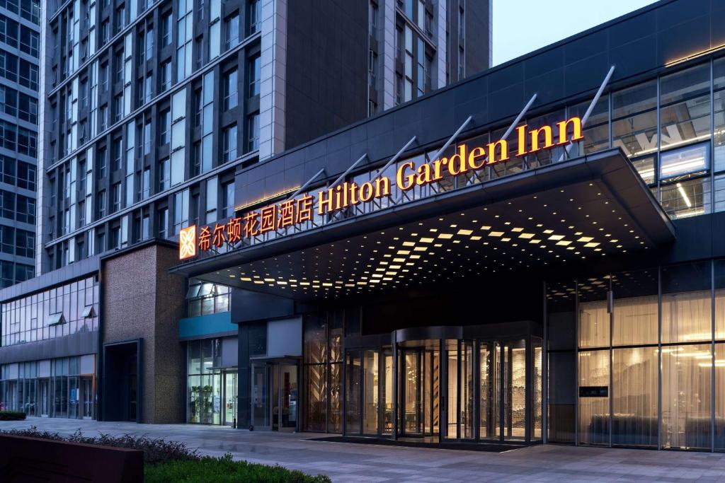 Hilton Garden Inn Hefei Binhu New District في خفي: مبنى عليه لافته مكتوب عليها نزل الحديقه الامريكيه