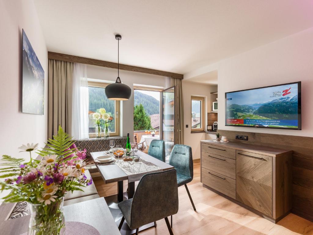 a living room with a dining table and a tv at Schöne Aussicht Apartments in Tux