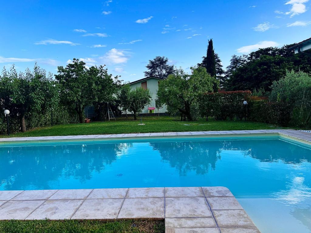 una piscina con acqua blu in un cortile di Villa Anna with pool and lift a Capannori