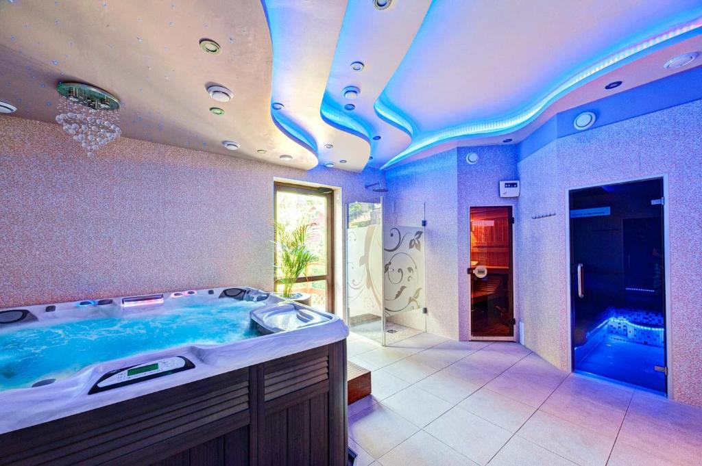uma grande casa de banho com banheira e uma televisão em Karkonoski SPA - Bufet mini All Inclusive gratis! em Karpacz